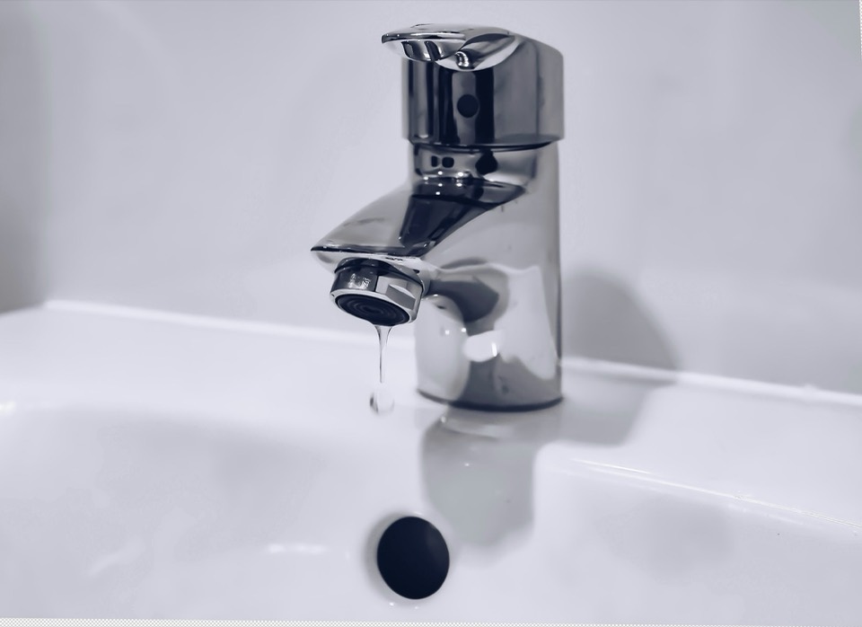 Robinet en acier inoxydable sur un lavabo blanc